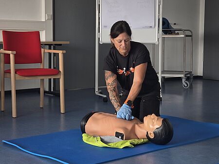 Silke Diefenbach präsentiert an einer Puppe die Handgriffe zur Wiederbelebung. 